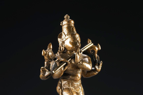 Bronze figure of Krishna, standing playing the flute.